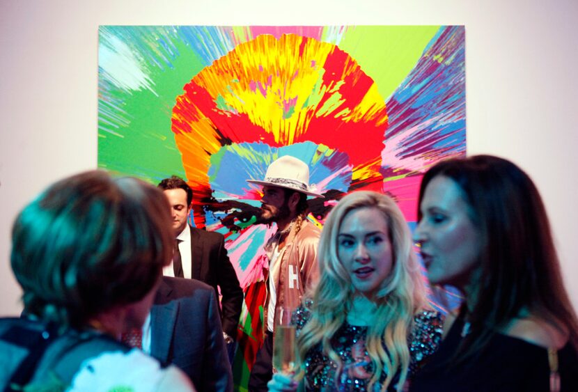 Hair designer Charlie Price, in a hat, is photographed in front of a painting of George...