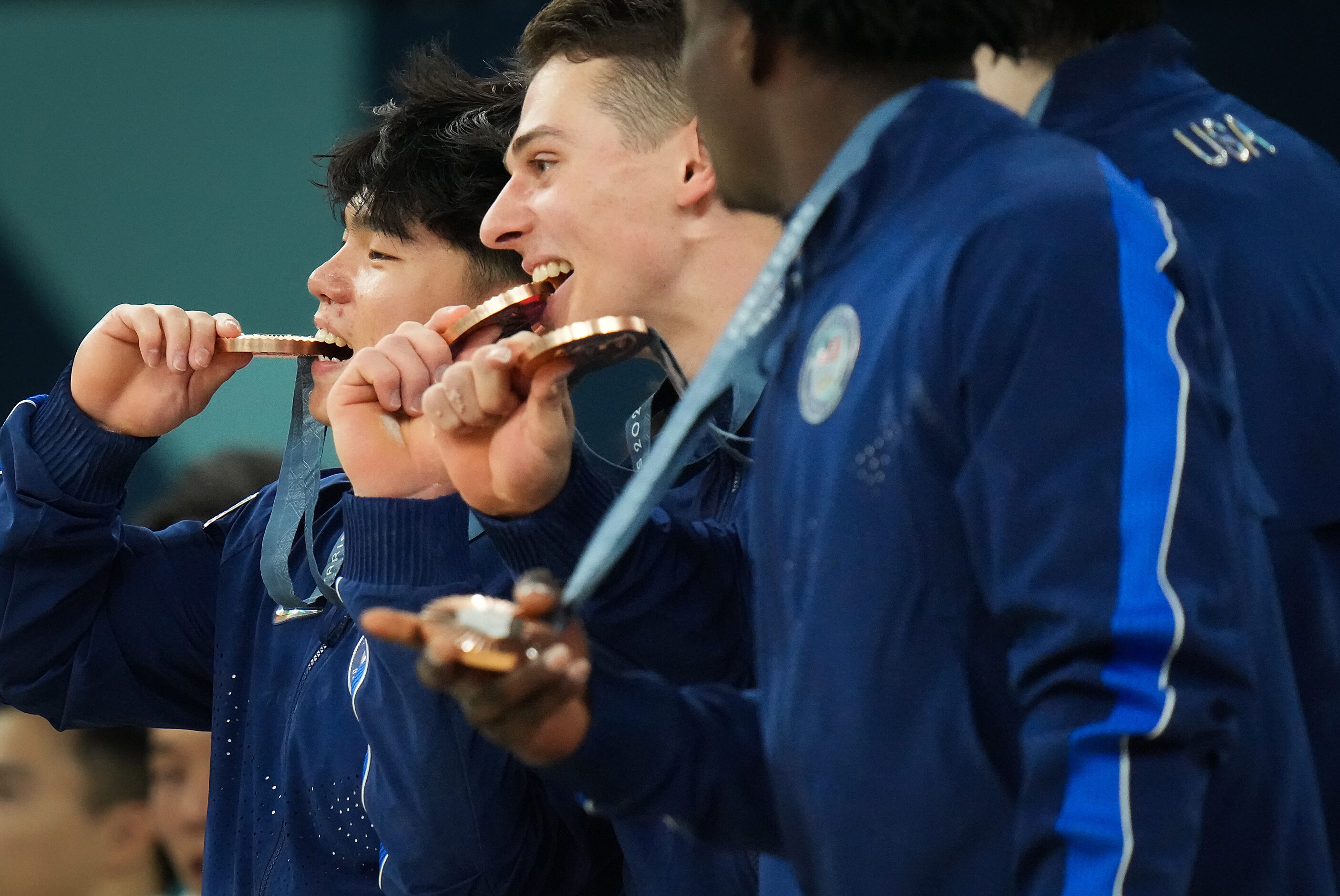 Asher Hong (left) and Paul Duda of the United States pose with teammates and their medals...