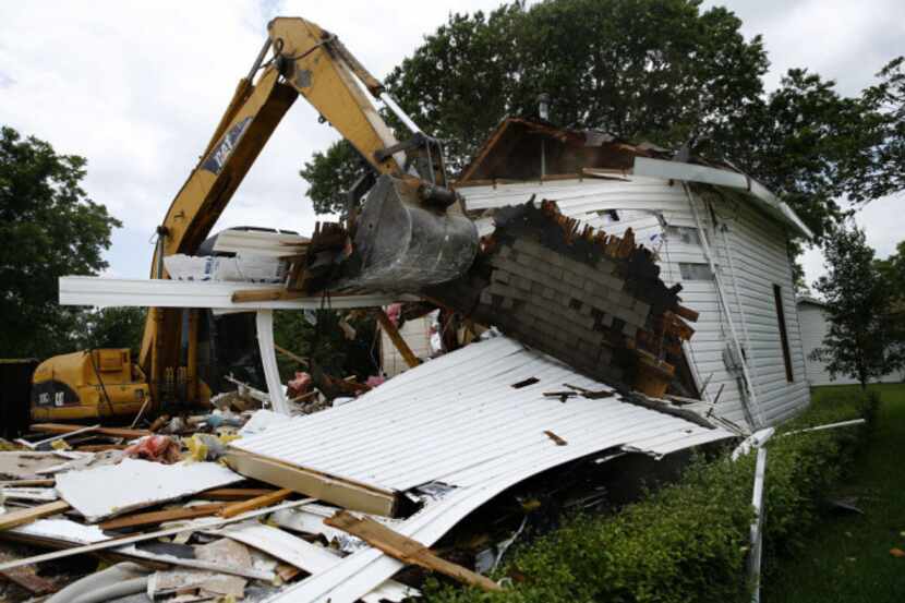 A demolition shovel tears down the Webre's two-story home at Reagan St. and Spring St. in...