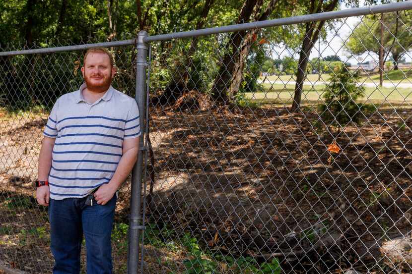 Homeowner Blake Smith leans against his existing fence in Dallas, Thursday, July 6, 2023....