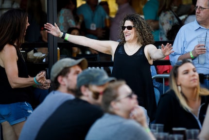 Meryl Evans greets her friend Cheryl Kool (left) before a concert. Evans got cochlear...