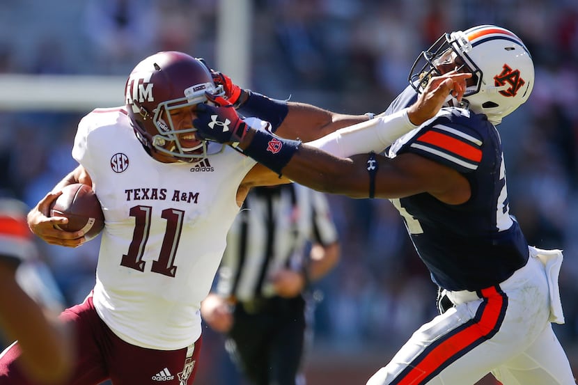 Auburn defensive back Daniel Thomas (24) grabs the facemask of Texas A&M quarterback Kellen...