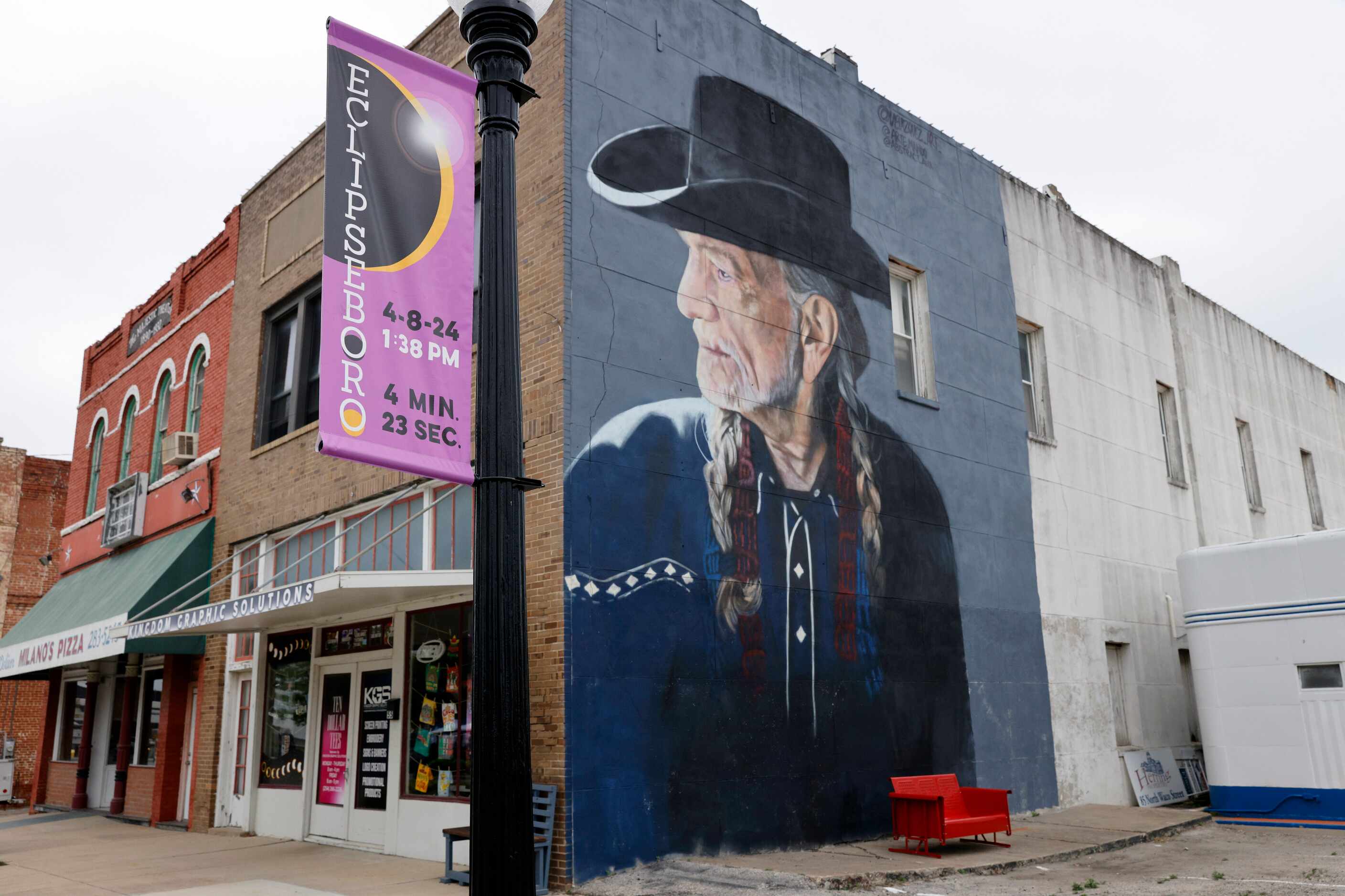 A mural of Willie Nelson looks towards an Eclipseboro banner before a total solar eclipse,...