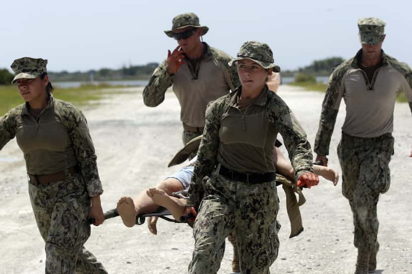 In this Aug. 13, 2013, photo, U.S. Navy Master-at-Arms Third Class Anna Schnatzmeyer (front...