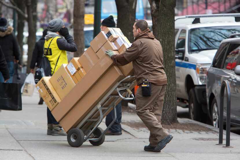 A United Parcel Service worker delivers packages on West 14th Street in New York, Dec. 26,...