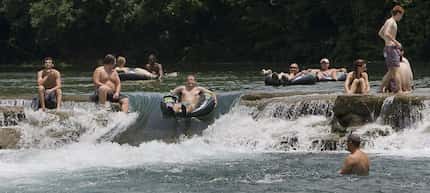 Tubers and swimmers have fun on the San Marcos River at City Park off of Cheatum Rd just...