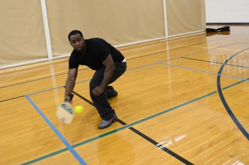 
Kieth Robinson reaches to paddle the ball during a round of pickleball. A former football...