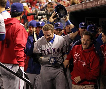 FILE - Teammates clamor around Josh Hamilton (center) after his two-run homer put the...