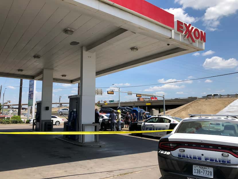 Dallas police cordoned off the parking lot at the Exxon gas station near where a man shot at...