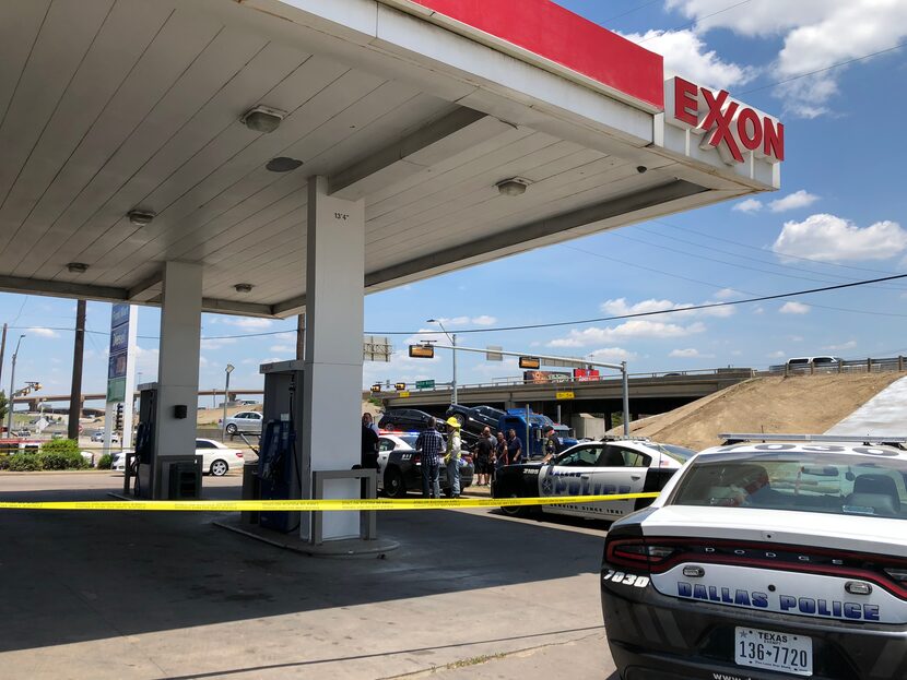 Dallas police cordoned off the parking lot at the Exxon gas station near where a man shot at...