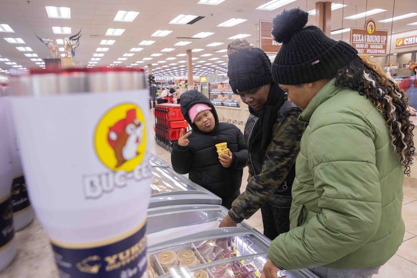 (From left) Amanda Martinez, 11, poses for the camera while looking at the ice cream section...