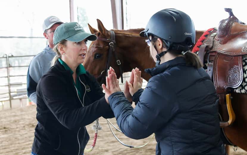 ManeGait Therapeutic Horsemanship instructor Antoinette Rand gives Sara "Happy" Waterman...