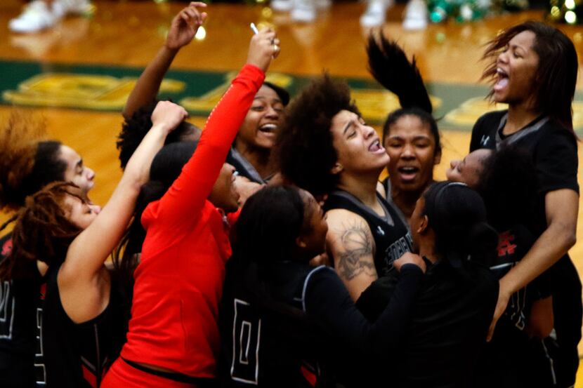 Cedar Hill forward Destinee McDowell (12), center, is mobbed by teammates after sinking a...