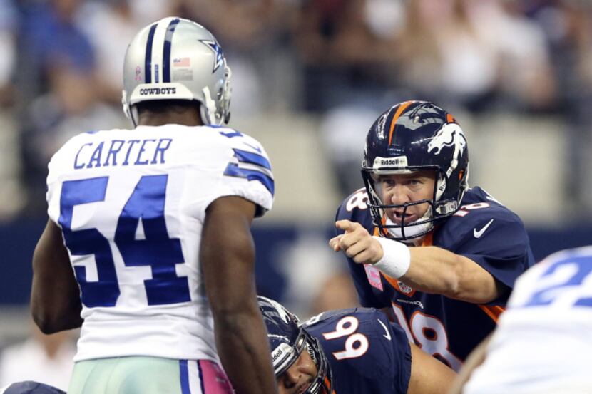 Denver Broncos quarterback Peyton Manning (18) points out Dallas Cowboys outside linebacker...