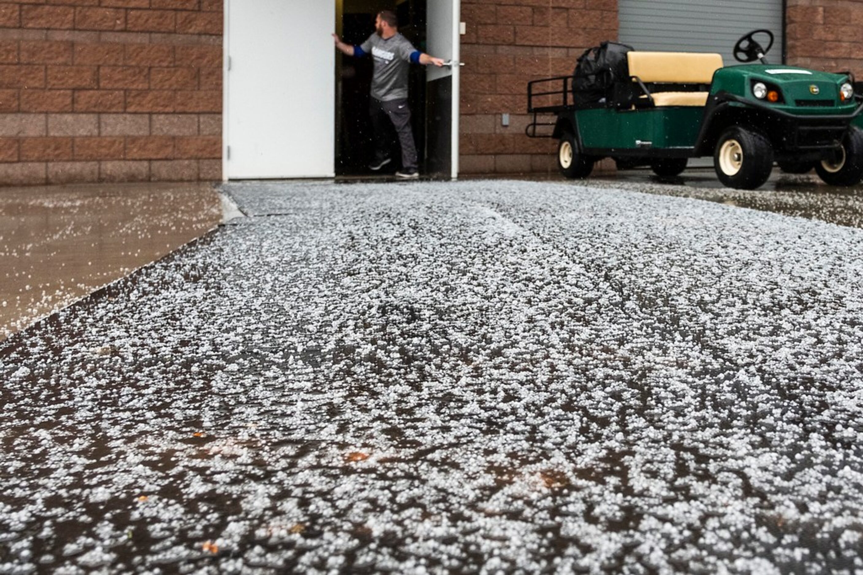 Snow pellets collect outside the Texas Rangers clubhouse door following a spring training...