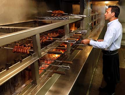 A gaucho chef prepares meat at a Fogo de Chao restaurant.