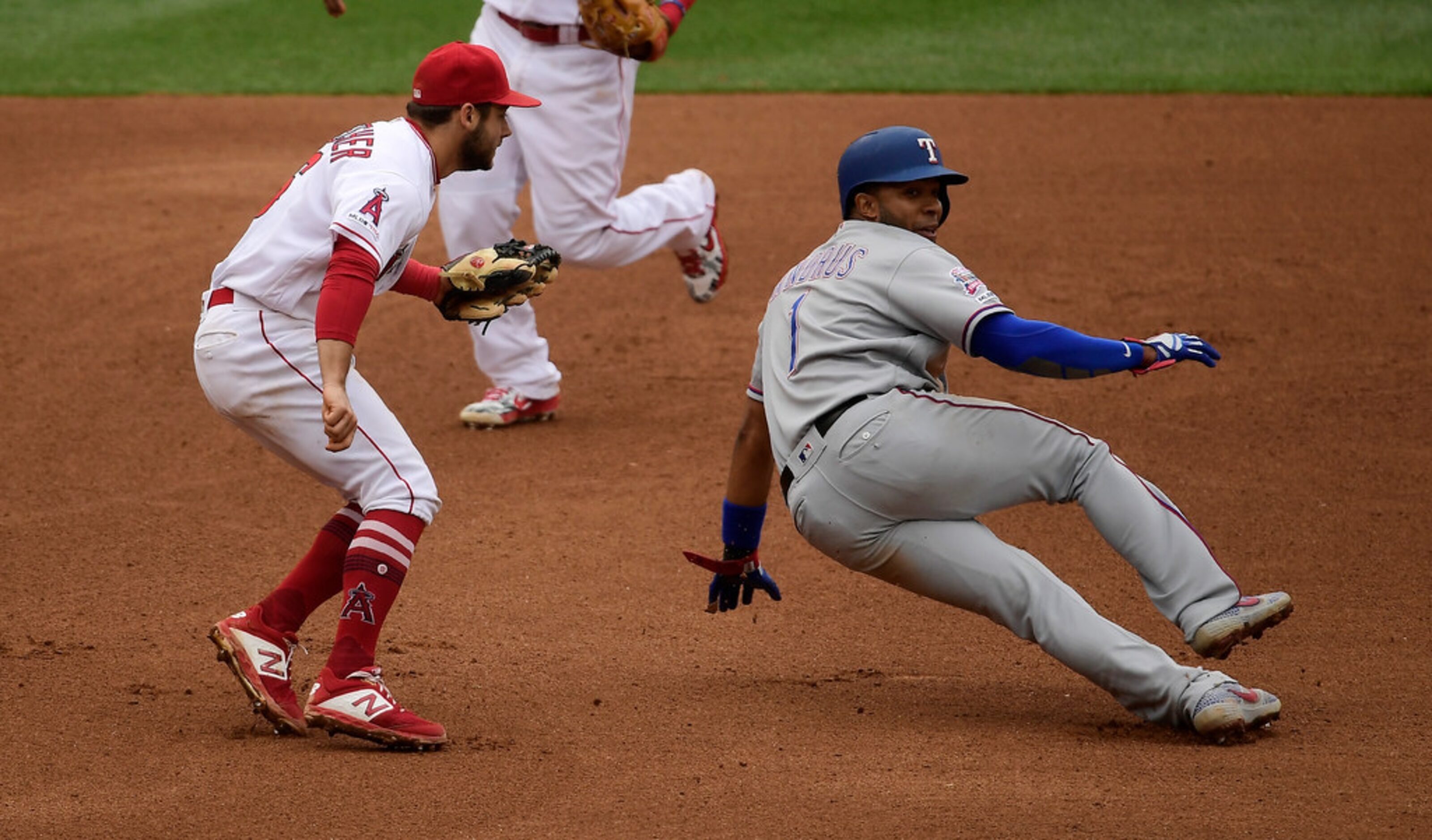 Texas Rangers' Elvis Andrus, right, is tagged out by Los Angeles Angels third baseman David...