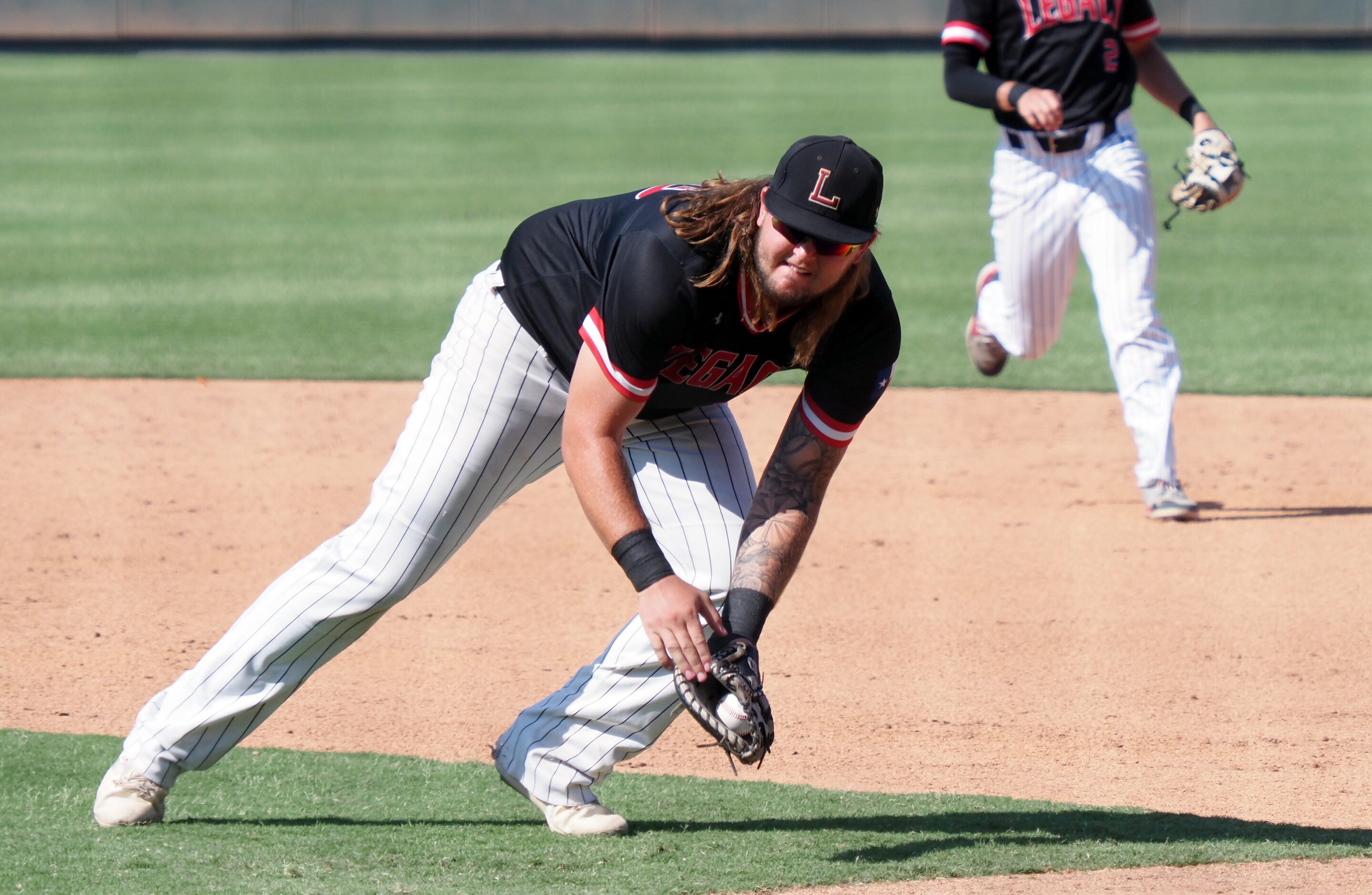 Mansfield Legacy first baseman Kayden Voelkel (left) scoops top a short ground ball for an...