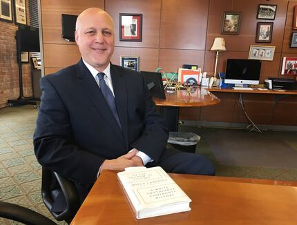 New Orleans Mayor Mitch Landrieu poses with a copy of his new book, "In the Shadow of...