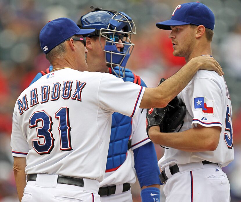  Texas pitching coach Mike Maddux and catcher AJ Pierzynski talk with struggling starter...