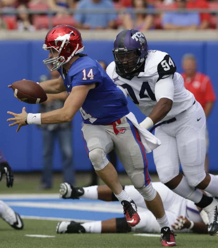 SMU quarterback Garrett Krstich (14) is sacked by TCU defensive end Josh Carraway (94)...