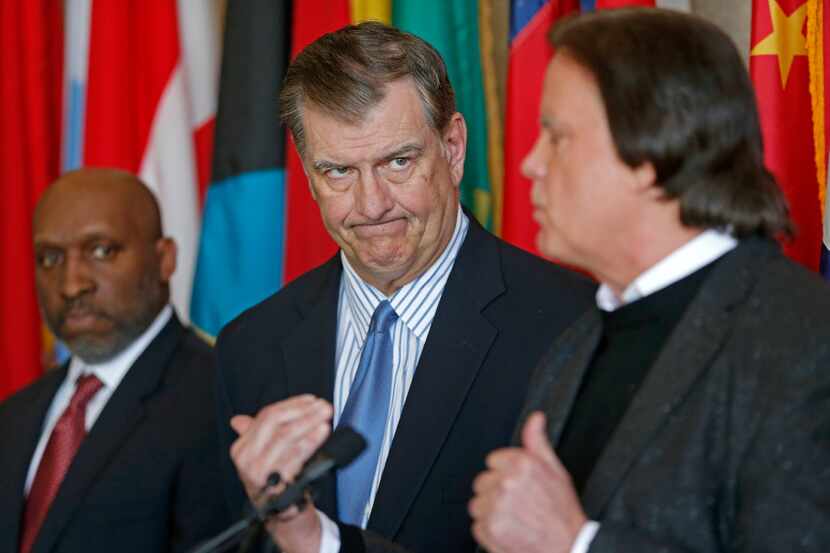 Dallas Mayor Mike Rawlings, center, looks at David R. Carey, right, Executive Vice President...