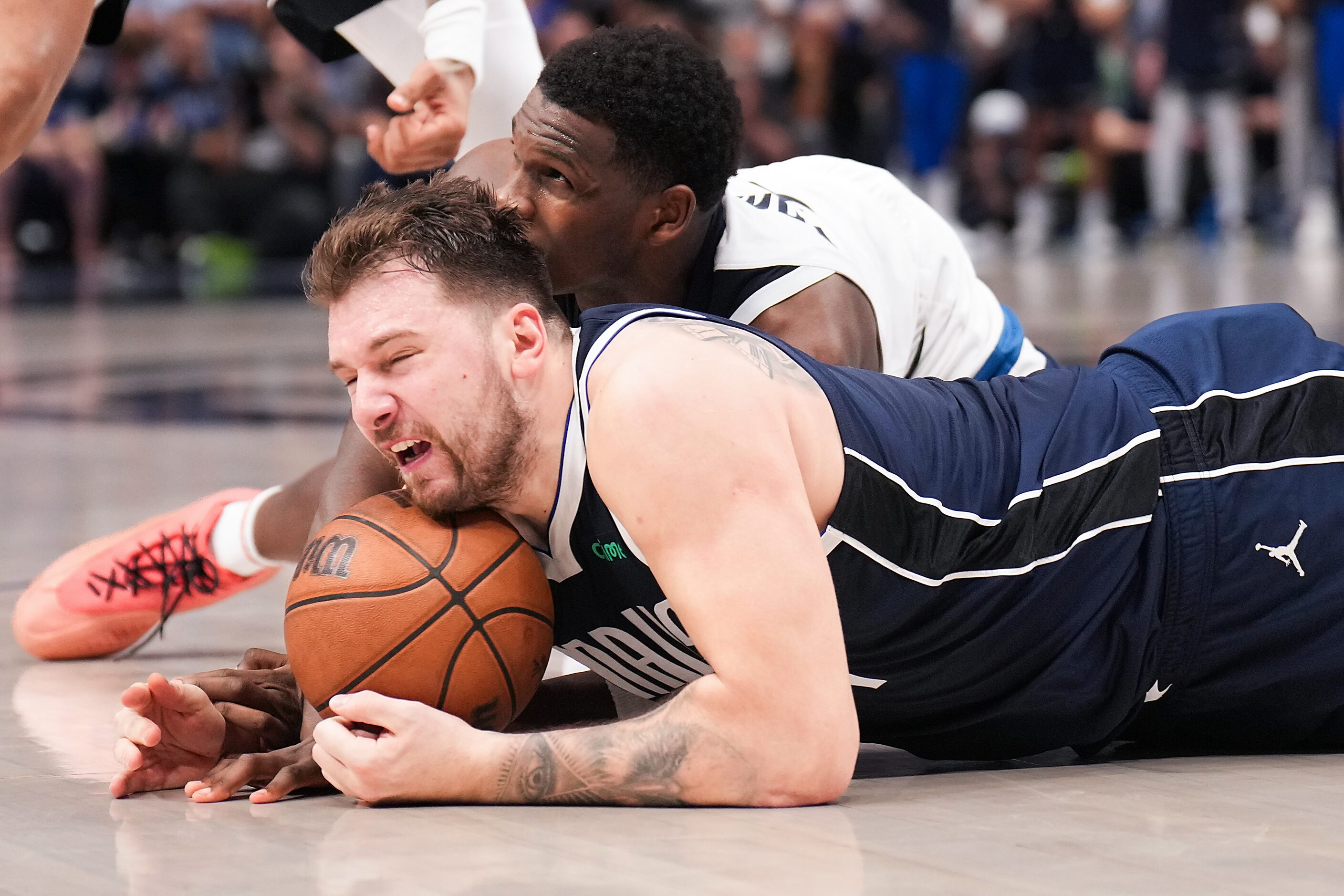 Dallas Mavericks guard Luka Doncic (77) wrestles Minnesota Timberwolves guard Anthony...