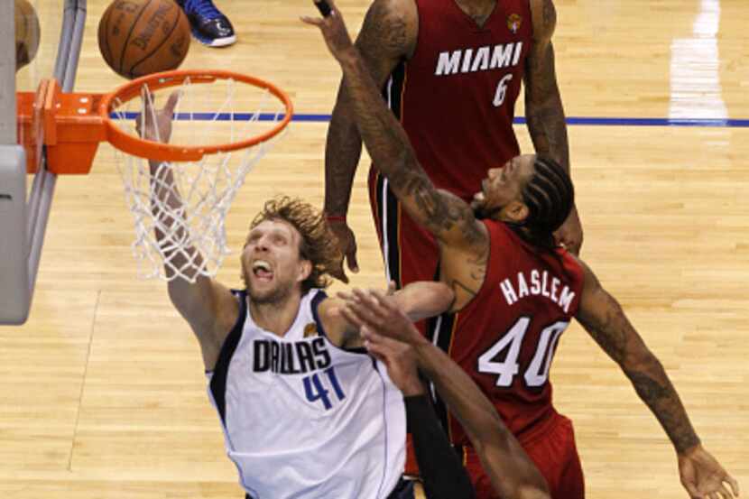 Dallas Mavericks power forward Dirk Nowitzki (41) slaps hand with fans after defeating the...