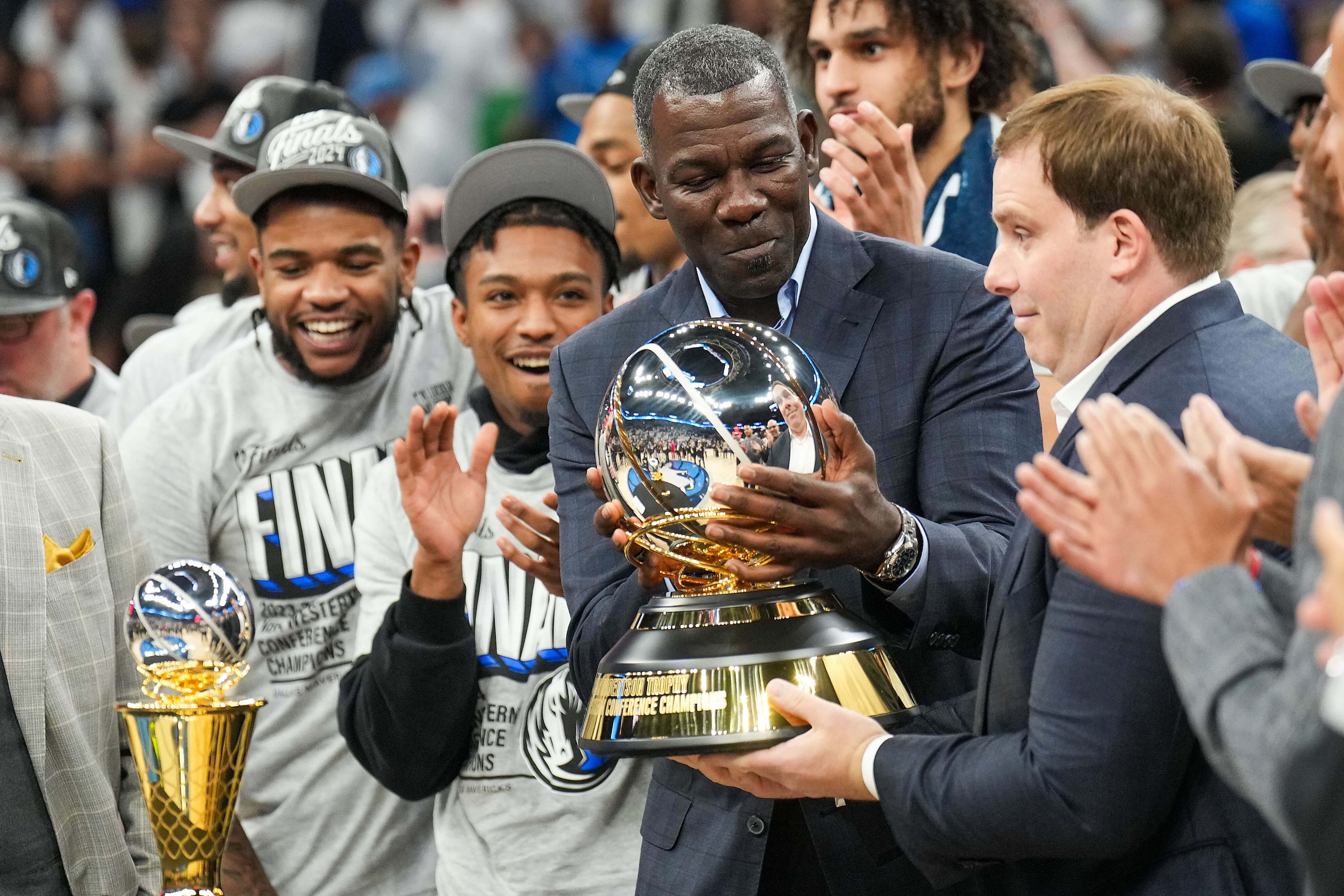 Dallas Mavericks assistant general manager Michael Finley hands the championship trophy to...