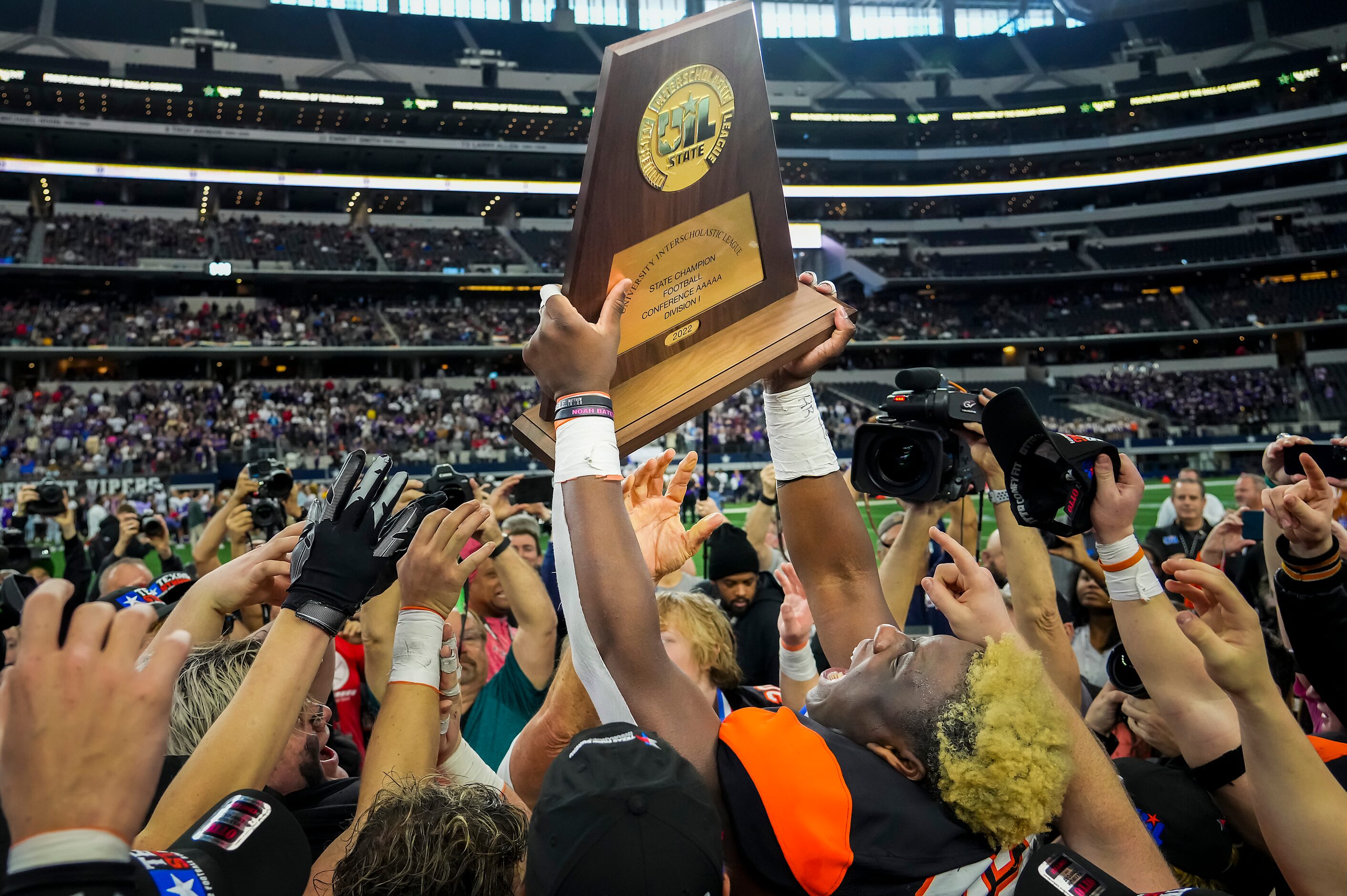 Aledo defensive lineman Ansel Din-Mbuh (32) lifts the championship trophy with his teammates...