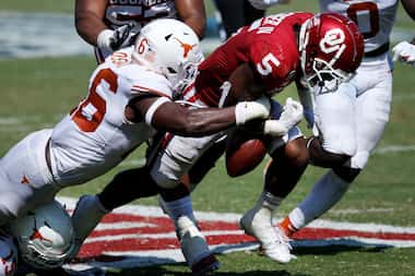 Texas Longhorns linebacker Joseph Ossai (46) forces a fumble by Oklahoma Sooners running...