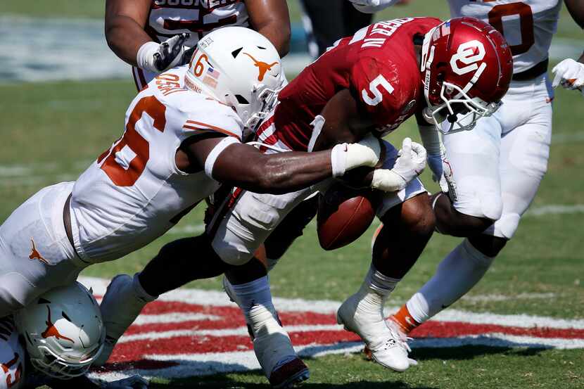Texas Longhorns linebacker Joseph Ossai (46) forces a fumble by Oklahoma Sooners running...