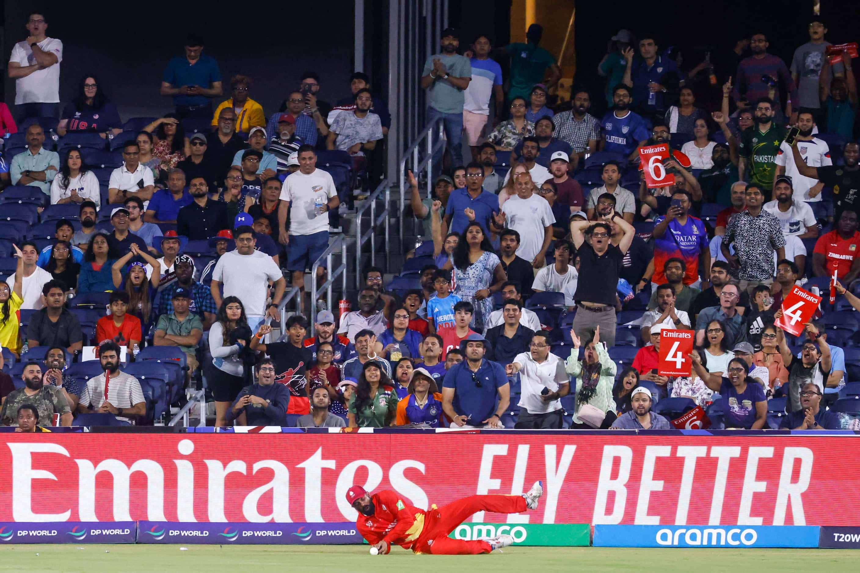 Crowd follows a fielder as he stops a boundary during the men's T20 World Cup cricket match...