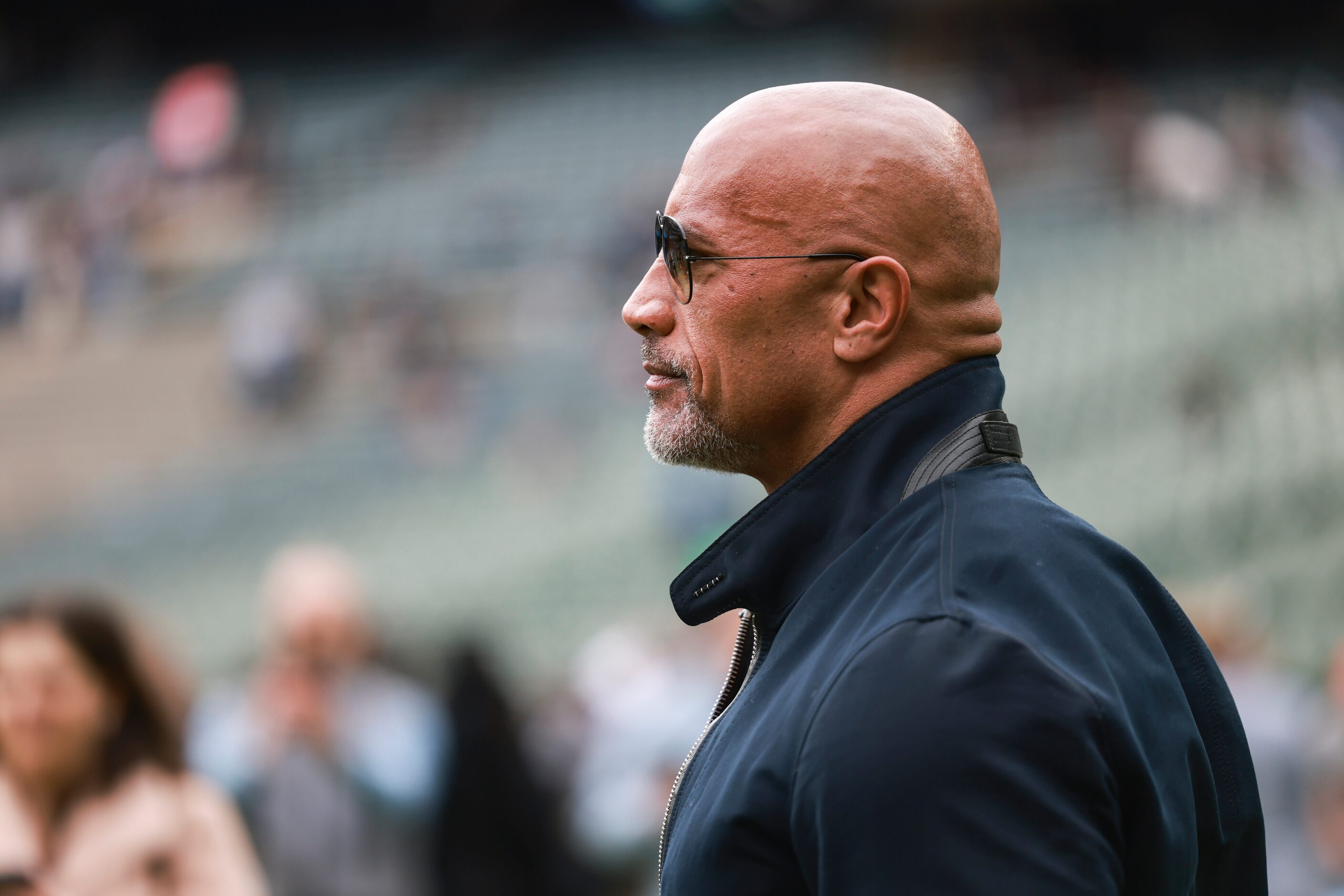 Dwayne “The Rock” Johnson stands on the sidelines before an XFL football game between the...