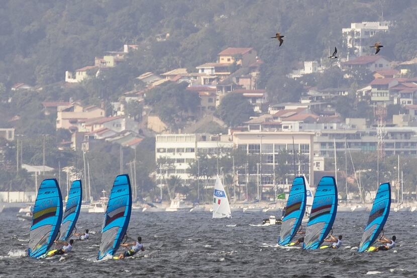 Competitors in the men's RS:X competition race in Guanabara Bay on the first day of sailing...