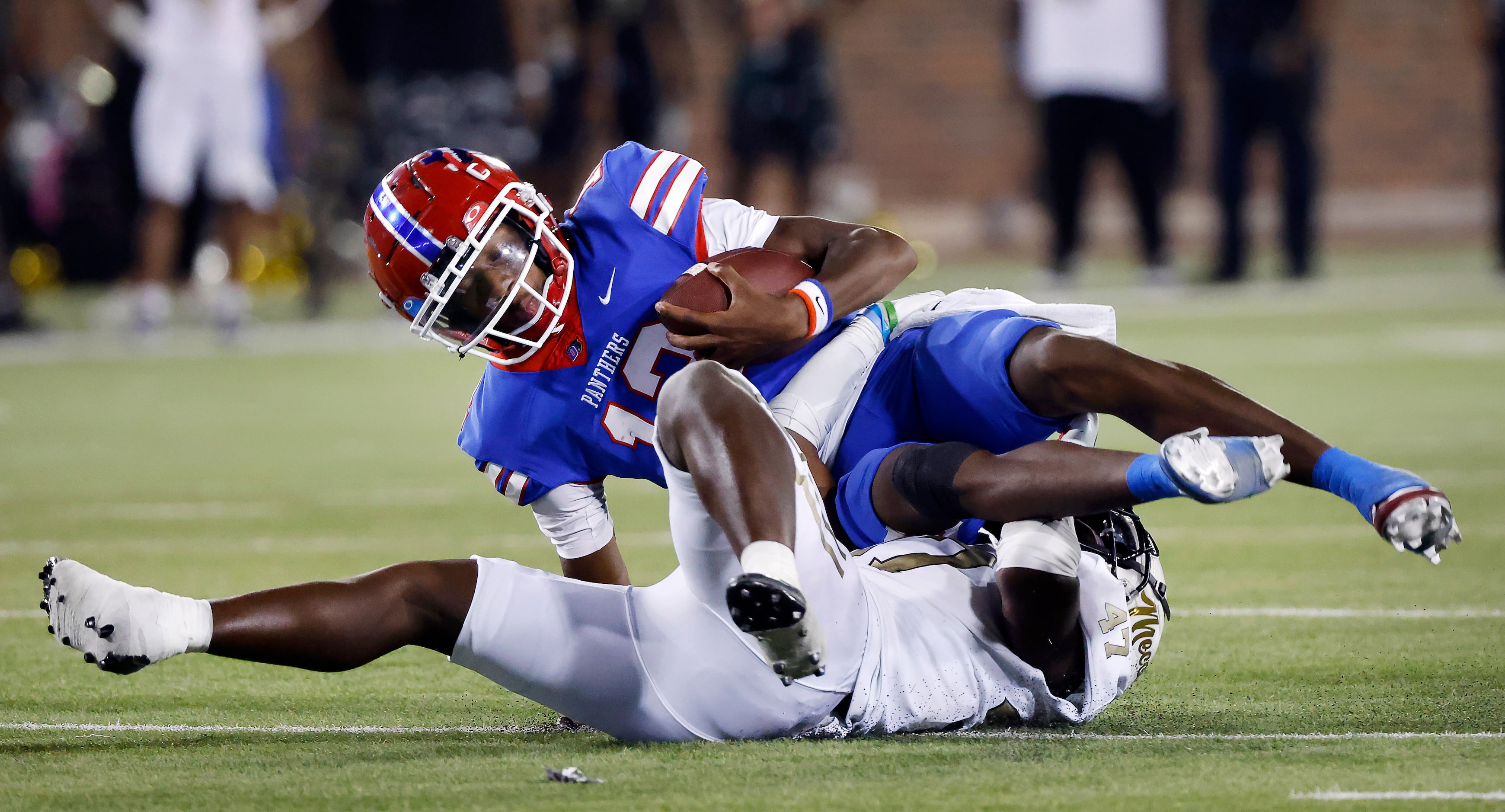 Duncanville quarterback Keelon Russell (12) is rolled up by South Oak Cliff linebacker Perry...