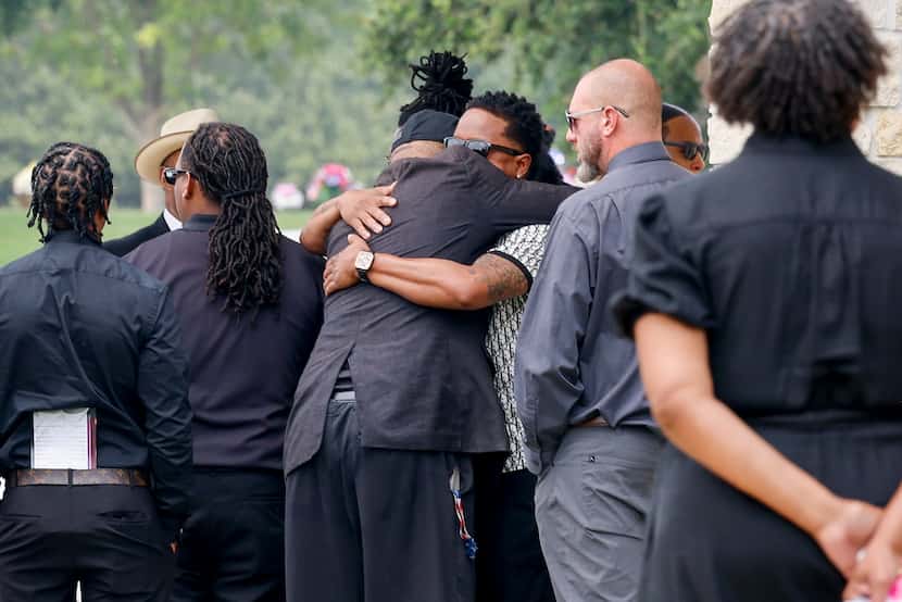 Mourners embrace after loading the caskets of Amaya Lockett, 24, and Jalisa Lockett, 22,...