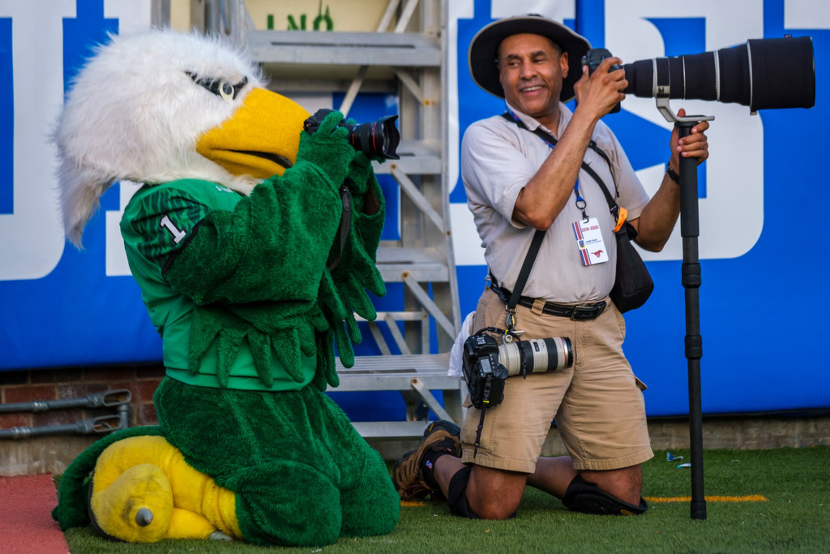 UNT mascot Scrappy shoots a photo with a camera borrowed from SMU athletics photographer...