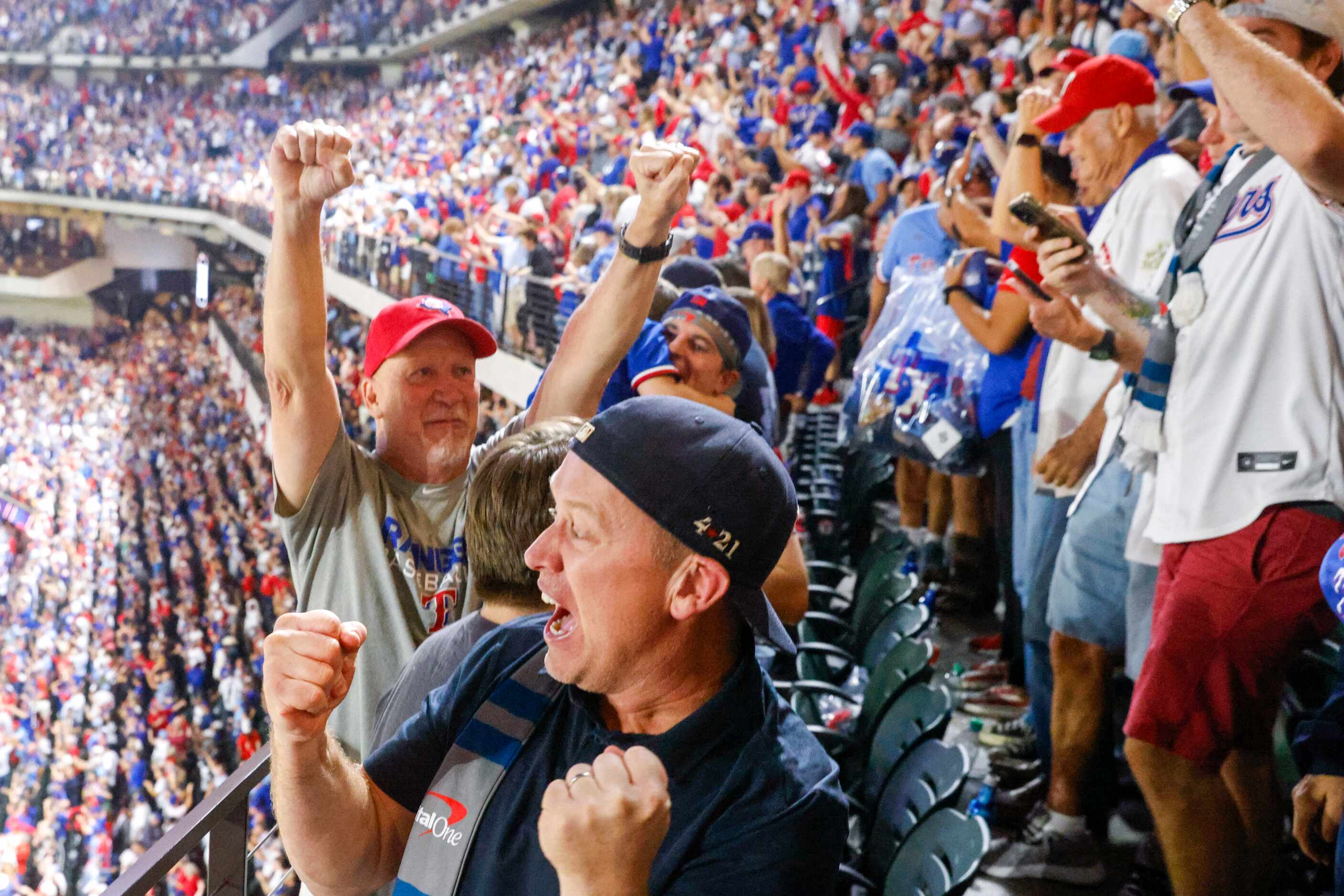 Texas Rangers fan Nick Wilhelmson of Keller (front) celebrates Adolis Garcia’s walk-off home...