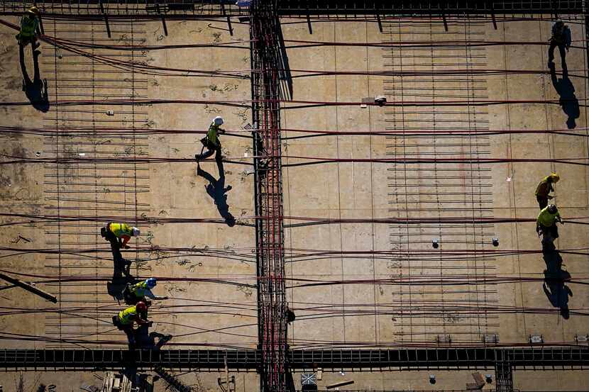 An aerial view of construction workers near the American Airlines Center in March. While...
