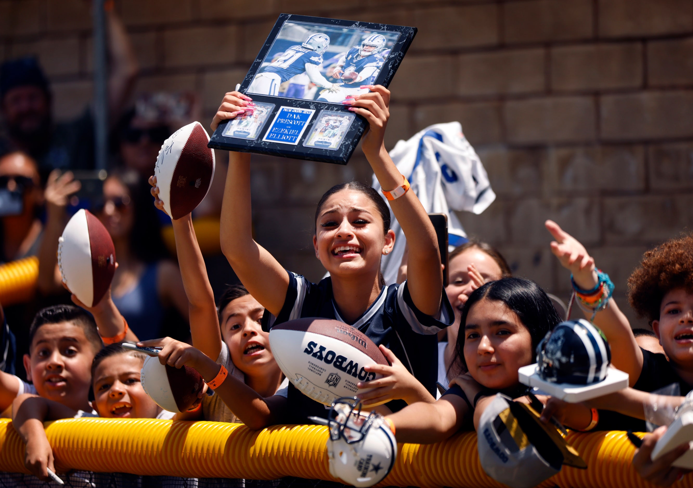 Young Dallas Cowboys fans scream for an autograph from Dallas Cowboys running back Ezekiel...