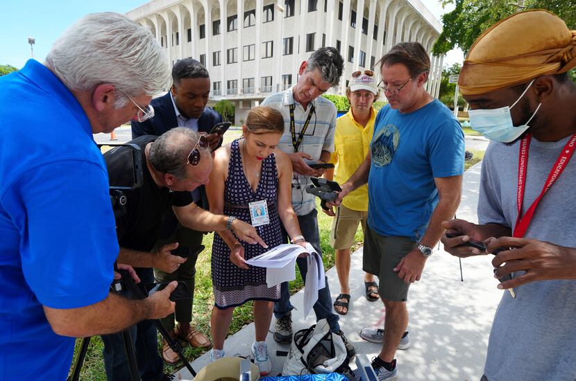 Journalists gather outside the Paul G. Rogers Federal Building and U.S. Courthouse in...