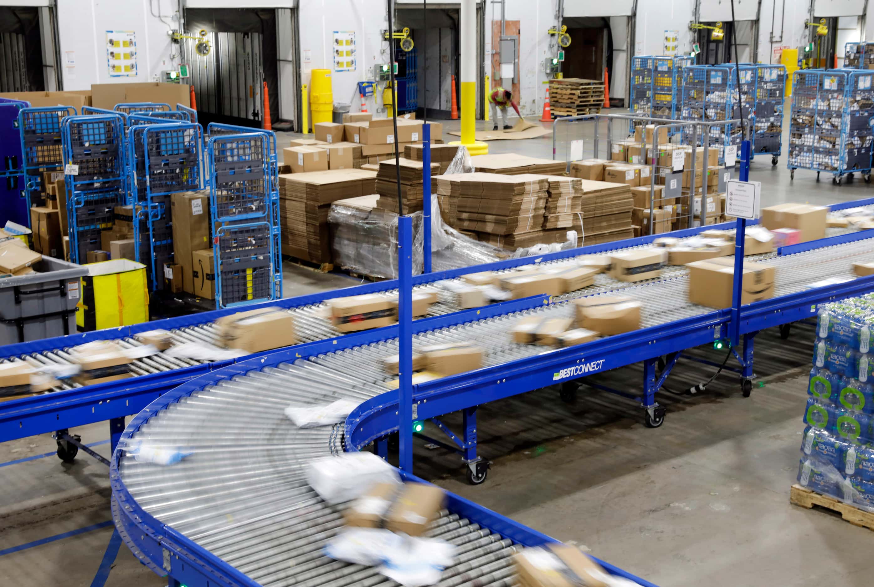 PRIME day deal packages move along the conveyor belts after being sorted off of trucks at...