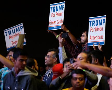 Supporters of Republican presidential candidate Donald Trump hold up signs as he speaks...