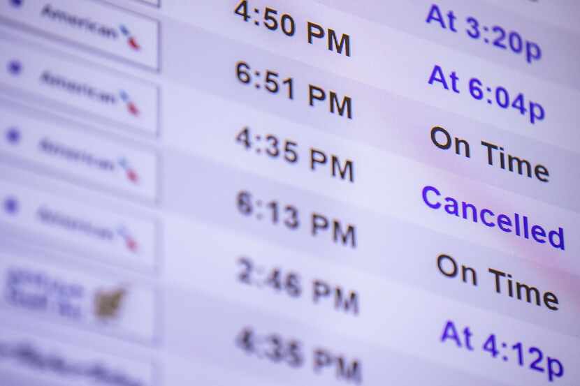 A screen shows a cancelled American Airlines flight in Terminal A of DFW Airport on Monday,...
