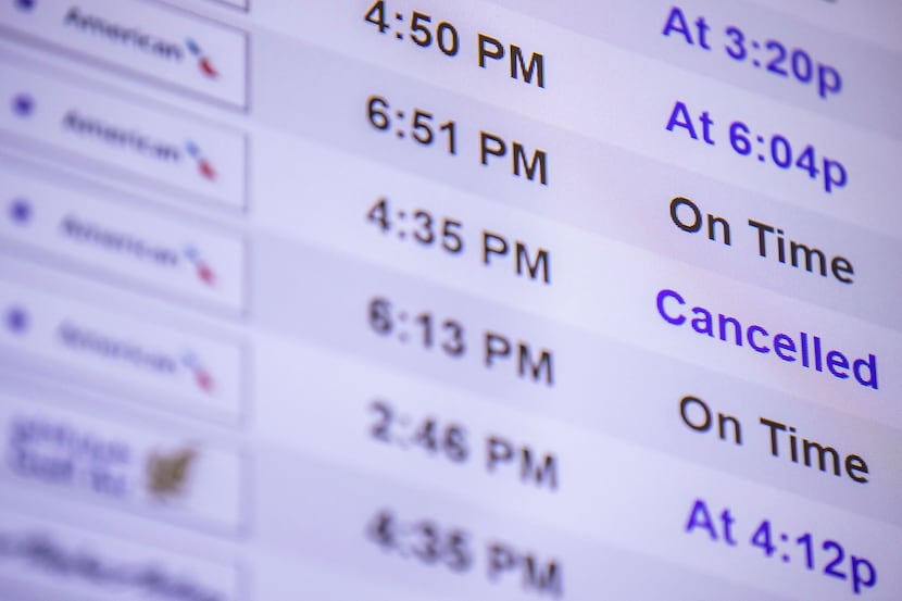 A screen shows a cancelled American Airlines flight in Terminal A of DFW Airport on Monday,...