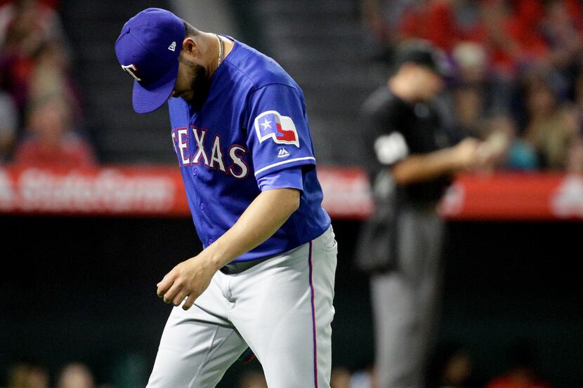 Texas Rangers pitcher Martin Perez leaves the baseball game after giving up two runs to the...