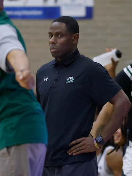 Mansfield Lake Ridge head basketball coach Cornelius Mitchell (center) looks at DeSoto head...