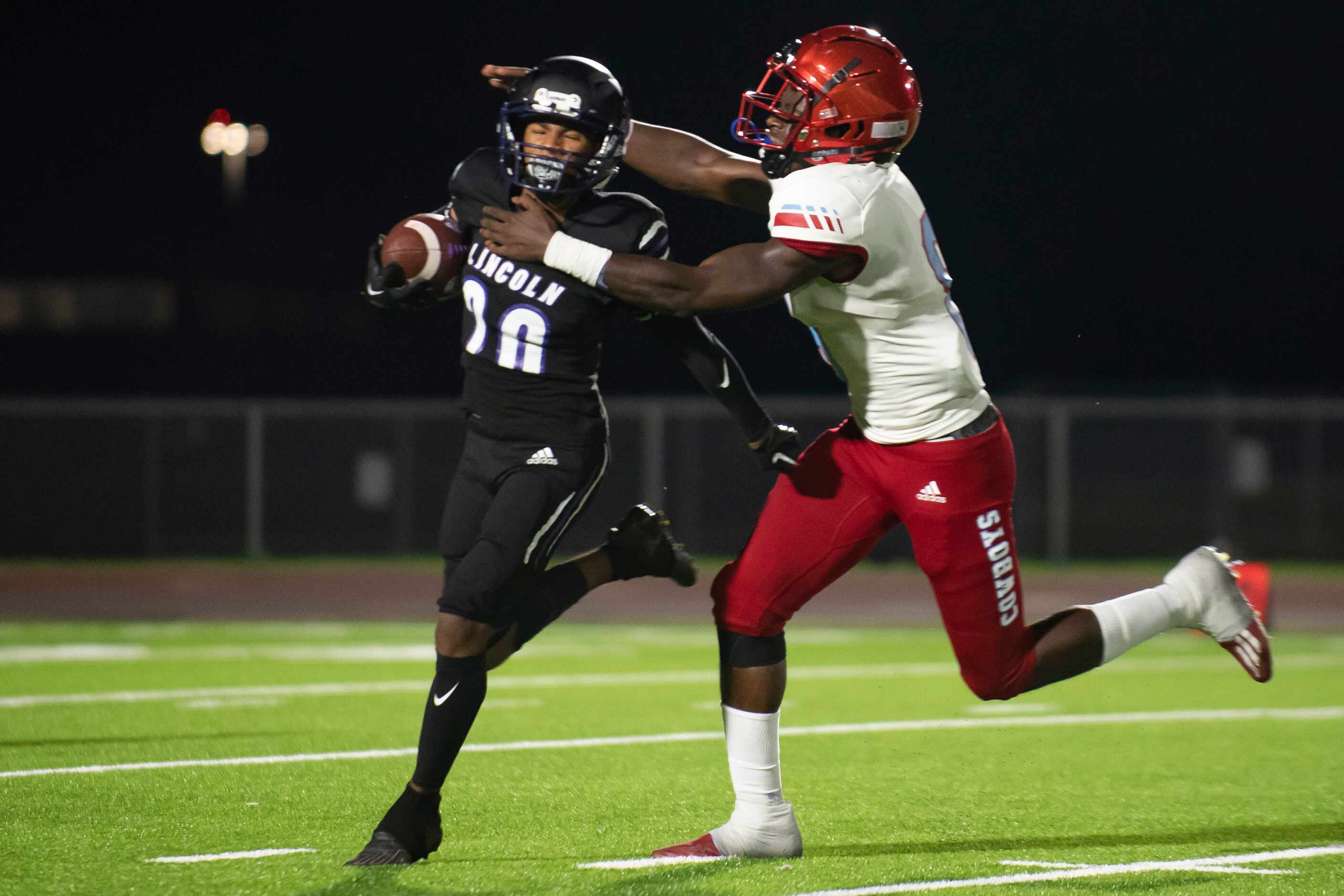 From left, Lincoln senior Drevion Washington (20) attempts to rush past Carter senior...