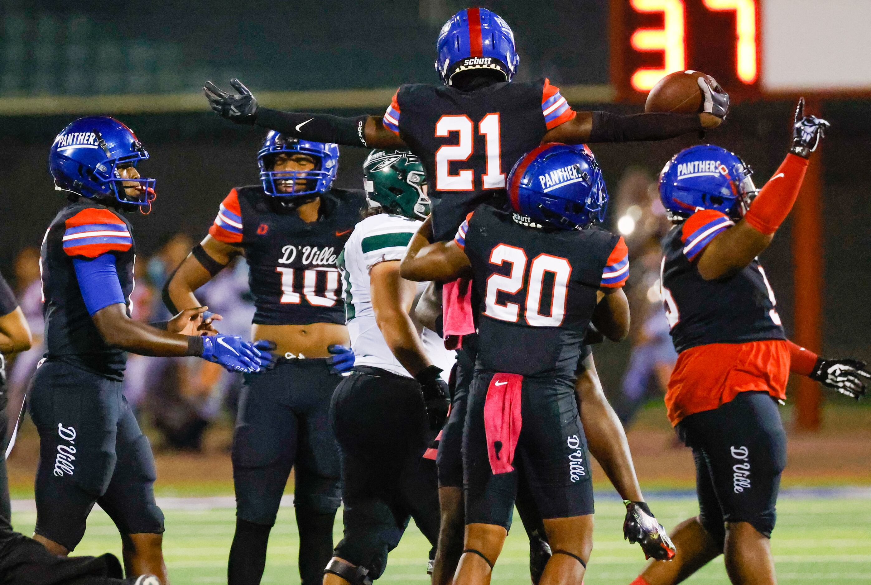Duncanville athletic Tyren Polley (21) is lifted by line backer Vernon Grant (20) in...